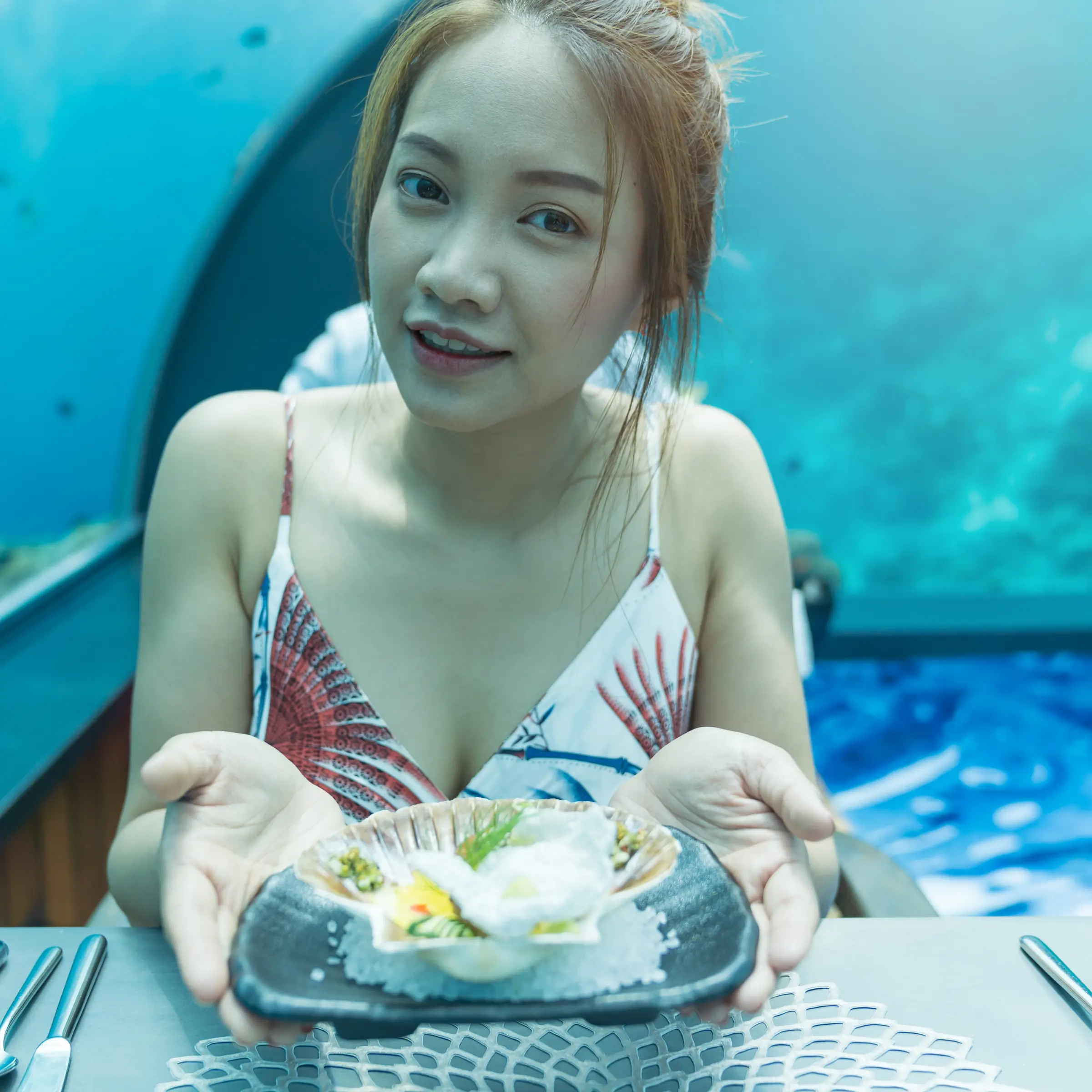 Azjatycka kobieta w podwodnej restauracji na Malediwach