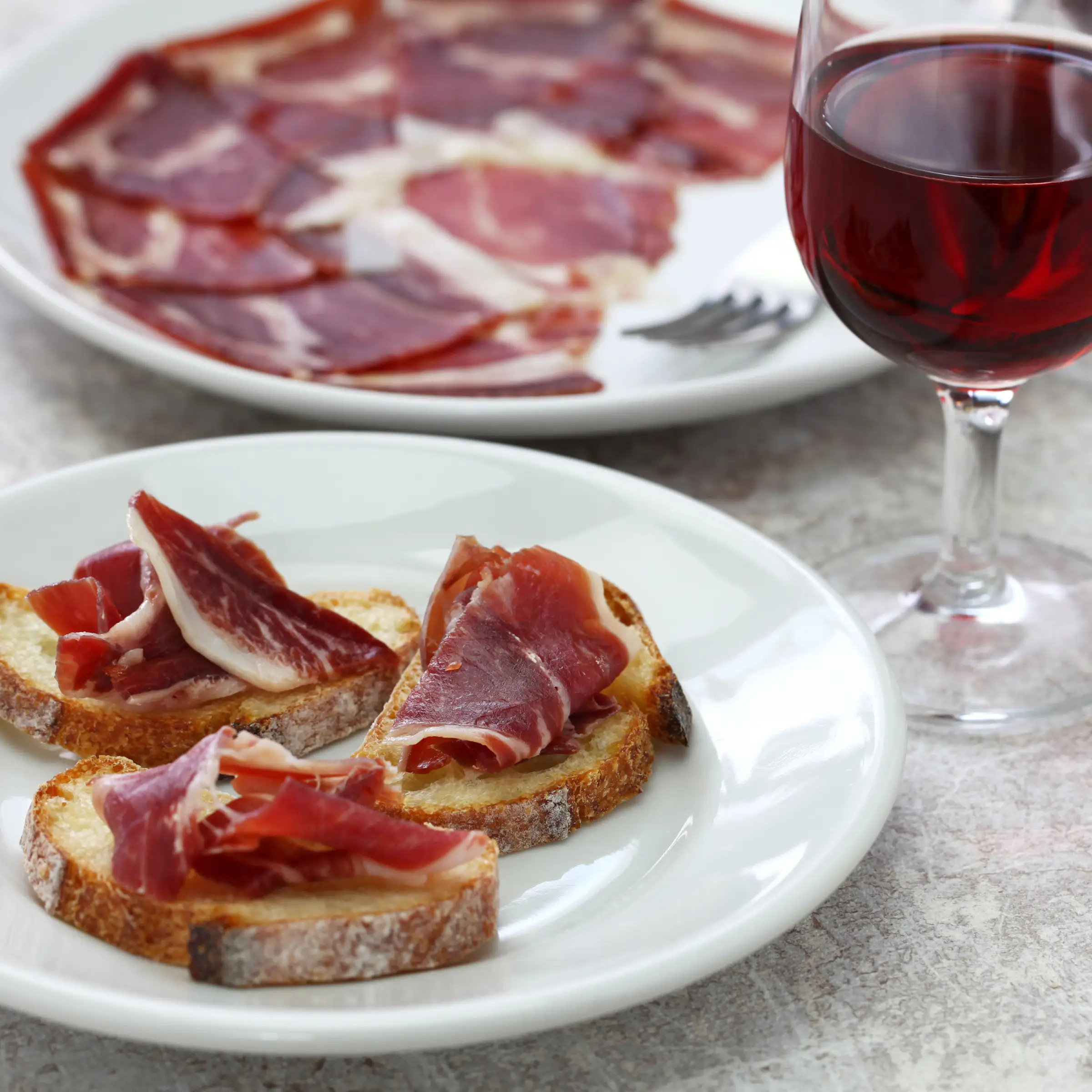 Hiszpańskie tapas z jamón ibérico podane z czerwonym winem.