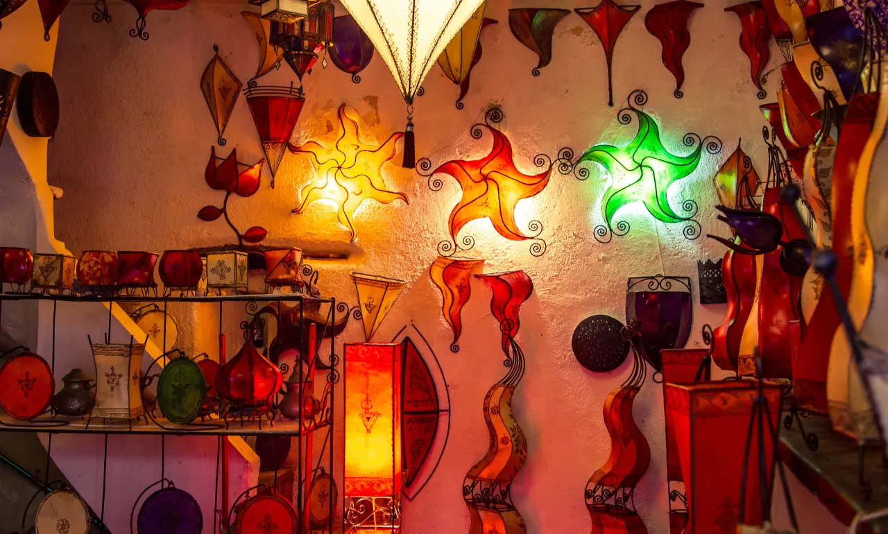 Tradycyjne ręcznie robione marokańskie lampy z kolorowej mozaiki szklanej na bazarze w Essaouirze, Maroko